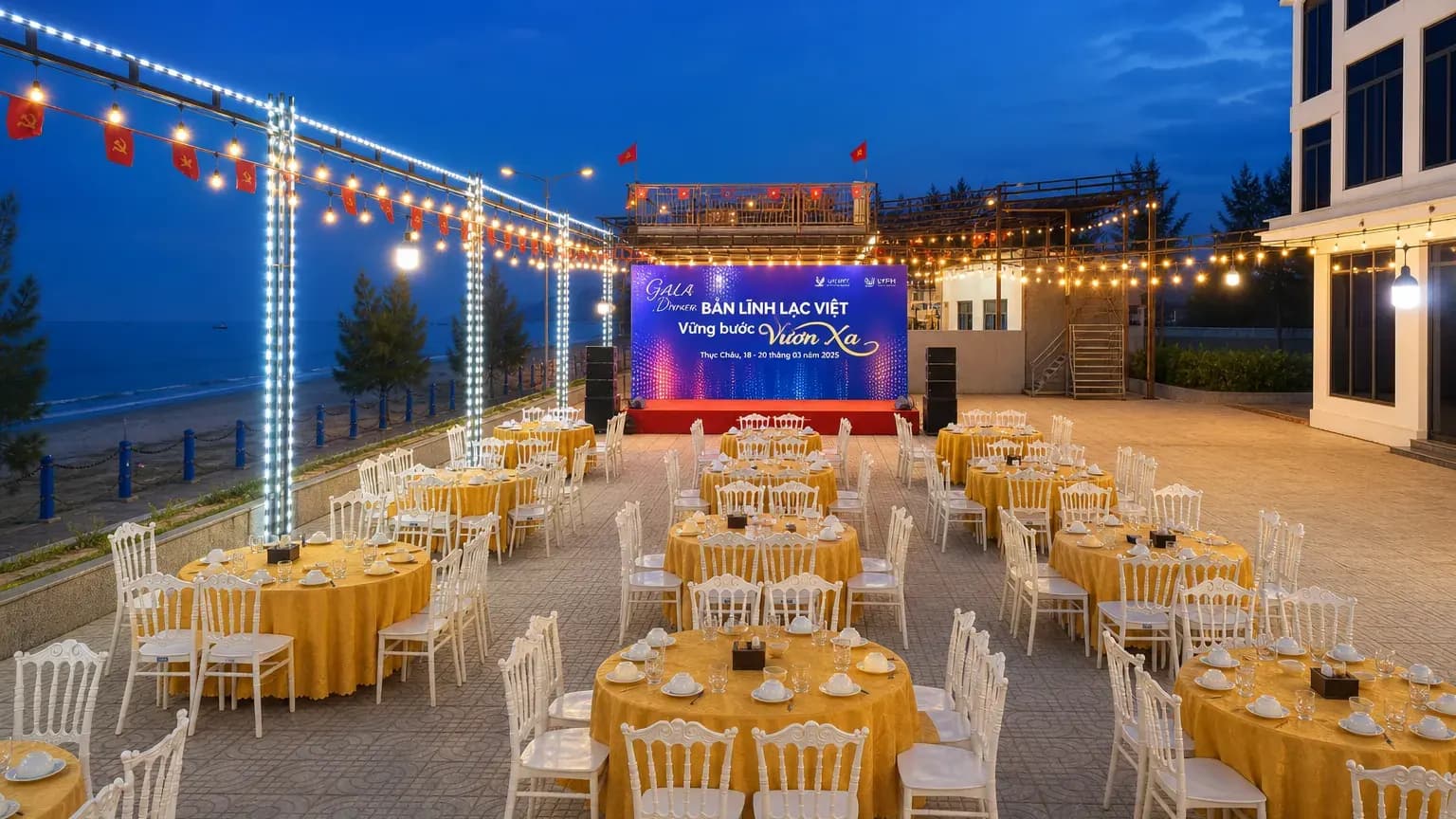 Toàn cảnh gala dinner ngoài trời ban đêm: hàng chục bàn tiệc dưới hệ thống đèn dây, sân khấu LED lớn nhìn ra biển Thiên Cầm